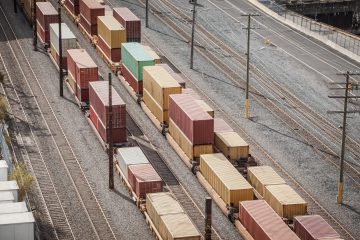 Rows,Of,Double,Stacked,Freight,Containers,Sit,On,Flatbed,Railcars